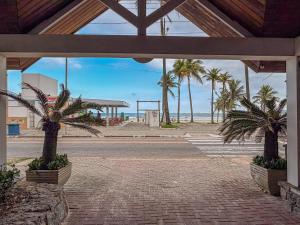 a pavilion with palm trees on the beach at Delphin Beach Hotel - Suíte 238 in Guarujá