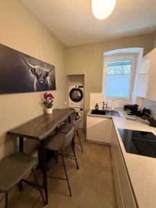 a kitchen with a table and chairs and a sink at Perfekte Wohnung mit Vollausstattung in Kiel