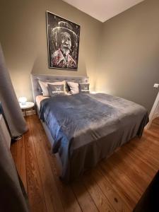 a bedroom with a bed with a painting on the wall at Perfekte Wohnung mit Vollausstattung in Kiel