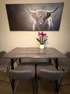a table with a picture of a cow on the wall at Perfekte Wohnung mit Vollausstattung in Kiel +2 photos