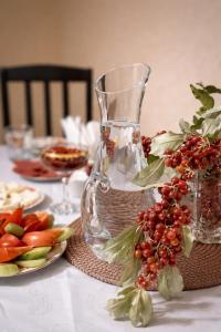 a table with a glass vase and a plate of fruit at Hotel Horizont Telavi in Telavi