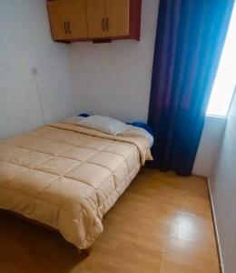 a small bedroom with a bed and a window at Smart San Miguel in Lima +2 photos