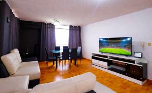 a living room with a couch and a flat screen tv at Smart San Miguel in Lima