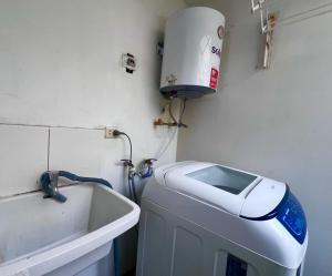 a washing machine sitting next to a sink in a room at Smart San Miguel in Lima