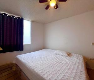 a bedroom with a bed and a ceiling fan at Smart San Miguel in Lima
