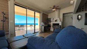 a living room with a blue couch and a view of the ocean at Beautiful Huge Beachfront Home Serenity Beach in Puerto Peñasco