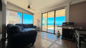 a living room with a couch and a view of the ocean at Beautiful Huge Beachfront Home Serenity Beach in Puerto Peñasco
