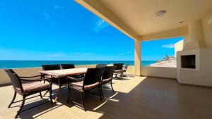 a dining room with a table and chairs and the ocean at Beautiful Huge Beachfront Home Serenity Beach in Puerto Peñasco