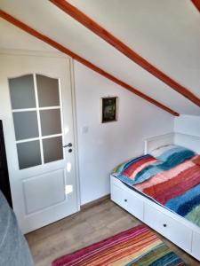 a bedroom with a bed and an open door at ZegZug apartman in Pankasz +6 photos