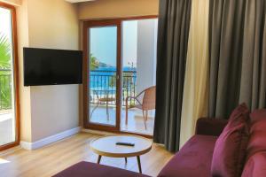 a living room with a couch and a flat screen tv at Hotel Vita Bella Resort & Spa in Gundogan