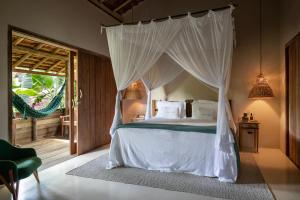 a bedroom with a bed with a canopy at Pousada Capim Santo in Trancoso +81 photos