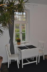 a dining room with a table and chairs and a window at Appartement Hundackerweg in Essen +18 photos