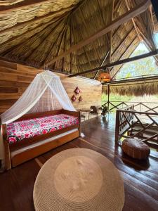 a room with a bed in a straw hut at Finca Flor de Maria in El Zaino
