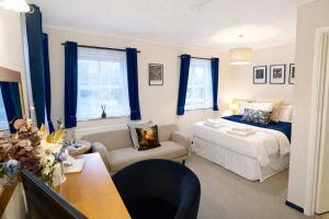 a bedroom with a bed and a chair and a table at The Inn at Emmington in Chinnor