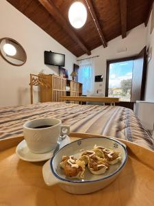 a cup of coffee and cookies on a table next to a bed at Artemisia Resort in Puntarazzi