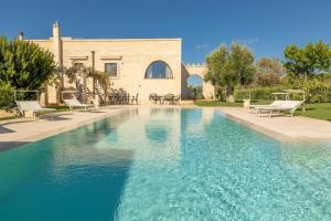 a swimming pool in front of a house at Villa Icaria in Carovigno