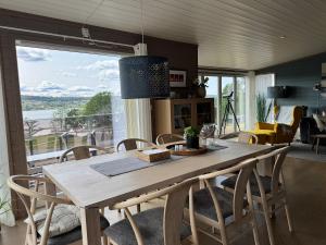 a dining room table with chairs and a large window at Modern cabin with panoramic views in Porsgrunn