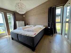 a bedroom with a bed in a room with windows at Modern cabin with panoramic views in Porsgrunn