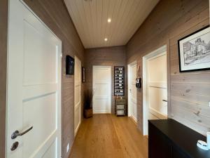 a hallway with wood paneling and a white door at Modern cabin with panoramic views in Porsgrunn