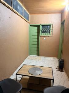 a room with a green door and a table and chairs at Studio spacieux Aéroport FHB in Abidjan