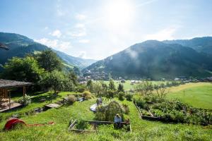 a group of people standing in a field with mountains at Reitbauernhof in Grossarl
