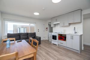 a kitchen and living room with a couch and a table at Oceanfront - Steps to Pier & Beach - Free Onsite Parking in White Rock