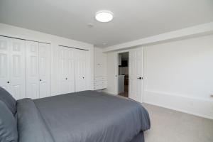 a bedroom with white cabinets and a gray bed at Oceanfront - Steps to Pier & Beach - Free Onsite Parking in White Rock