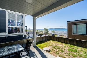 a balcony with a table and chairs and a view of the ocean at Oceanfront - Steps to Pier & Beach - Free Onsite Parking in White Rock