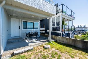 a house with a porch with a table and a balcony at Oceanfront - Steps to Pier & Beach - Free Onsite Parking in White Rock +11 photos