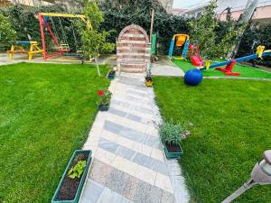 a backyard with a garden with a playground at Villa Sarvi in Durrës