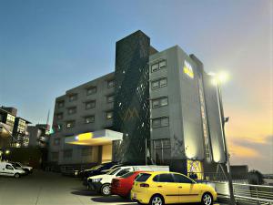 a parking lot with cars parked in front of a building at Hotel VM Express Queretaro in Mendiola