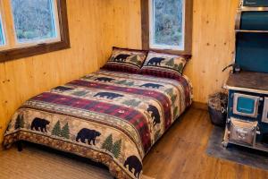a bedroom with a bed with a bear blanket at Le Chaleureux, Picanoc River in Kazabazua