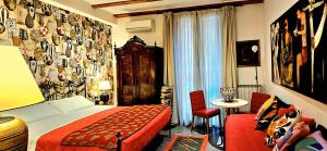 a hotel room with a bed and a table and chairs at La Foresteria Garden Boutique B&B in Catania