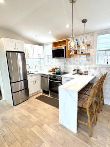 a kitchen with a refrigerator and a table with chairs at Ocean light | Deck + Patio • Central P-Town in Provincetown