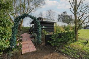 a garden with an arch and a walkway at The Carriage Ely Penzance in Ely +15 photos