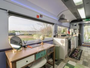a kitchen with a desk and a window in a trailer at The Carriage Ely Penzance in Ely