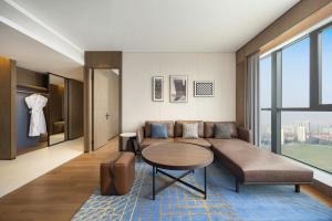 a living room with a couch and a table at Four Points by Sheraton Hefei, Qirui in Hefei