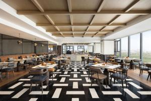 a restaurant with tables and chairs and large windows at Four Points by Sheraton Hefei, Qirui in Hefei