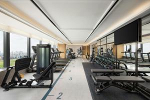 a gym with tread machines and a flat screen tv at Four Points by Sheraton Hefei, Qirui in Hefei