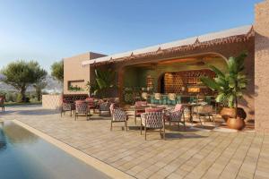 a patio with tables and chairs next to a pool at Amerruk, Marrakech, Autograph Collection in Marrakesh +11 photos