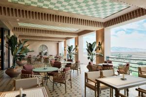 a restaurant with tables and chairs with a view at Amerruk, Marrakech, Autograph Collection in Marrakesh