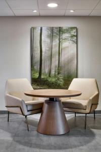 a table and two chairs in a room with a painting at Fairfield by Marriott Inn & Suites LaGrange in La Grange
