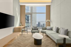a living room with a couch and a tv at AC Hotel by Marriott Hangzhou in Hangzhou