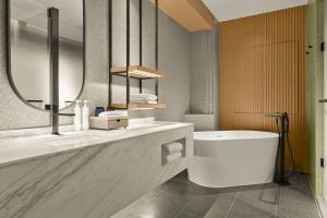a bathroom with a toilet and a sink and a mirror at AC Hotel by Marriott Hangzhou in Hangzhou +37 photos