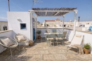 a patio with a table and chairs on a roof at La Chicca di Fiore - Guest House in Gallipoli