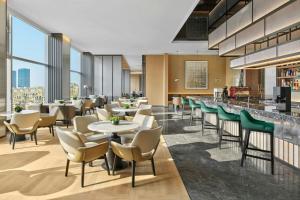 a restaurant with tables and chairs and a bar at AC Hotel by Marriott Hangzhou in Hangzhou