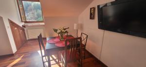 a dining room with a table and a flat screen tv at Ca Na Daniela in Carreña de Cabrales