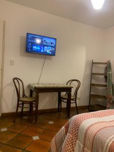 a room with a table and a tv on the wall at Comfort Suite in Vicente López