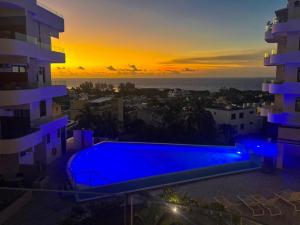 a swimming pool on the roof of a building at sunset at Sunset Ocean View Apartment in Flic-en-Flac