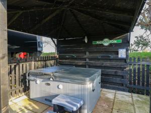 a hot tub sitting under a black umbrella at The Carriage Ely Paddington in Ely